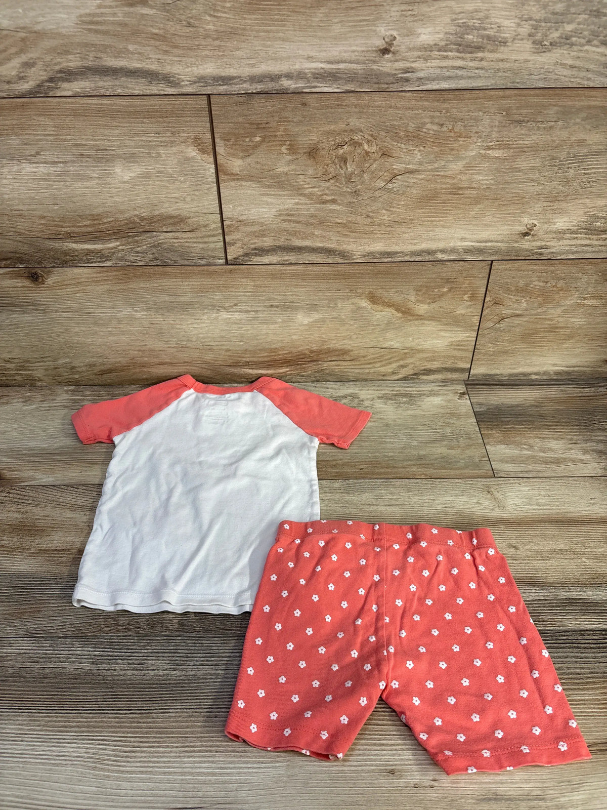 Top-down view of Member’s Mark 2pc pajama set, size 4T, with white top, coral sleeves, and floral-print shorts