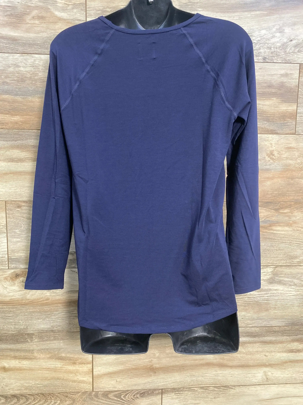 Back view of NWOT Gap Maternity Breathe Long Sleeve Shirt in navy on mannequin showcasing raglan seams and crewneck on wood plank floor