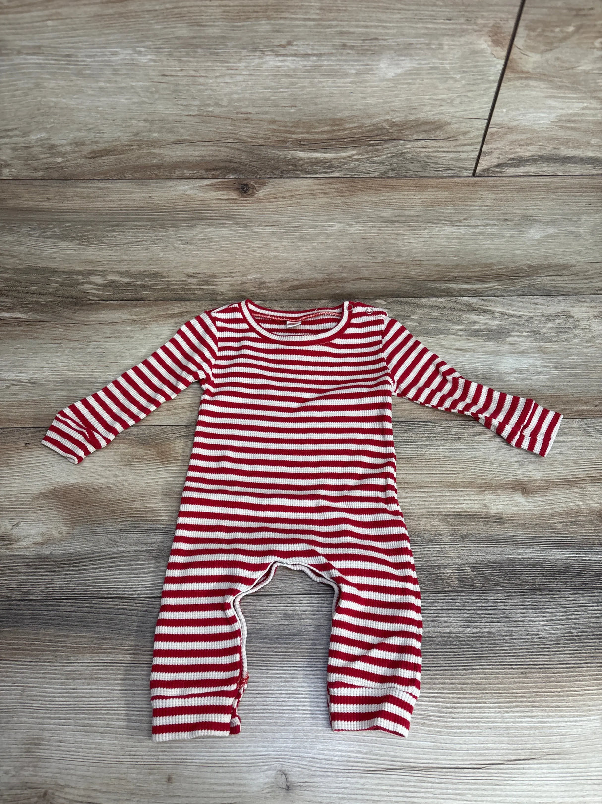 Red and white striped long-sleeve baby romper on wooden floor, kids clothing resale