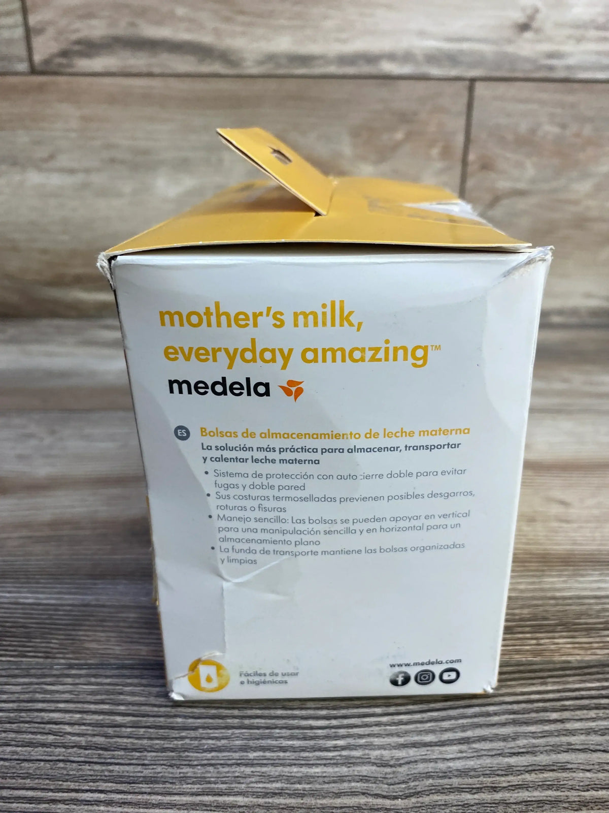 Front view of Medela breast milk storage bags box reading mother’s milk, everyday amazing with brand logo on wood surface