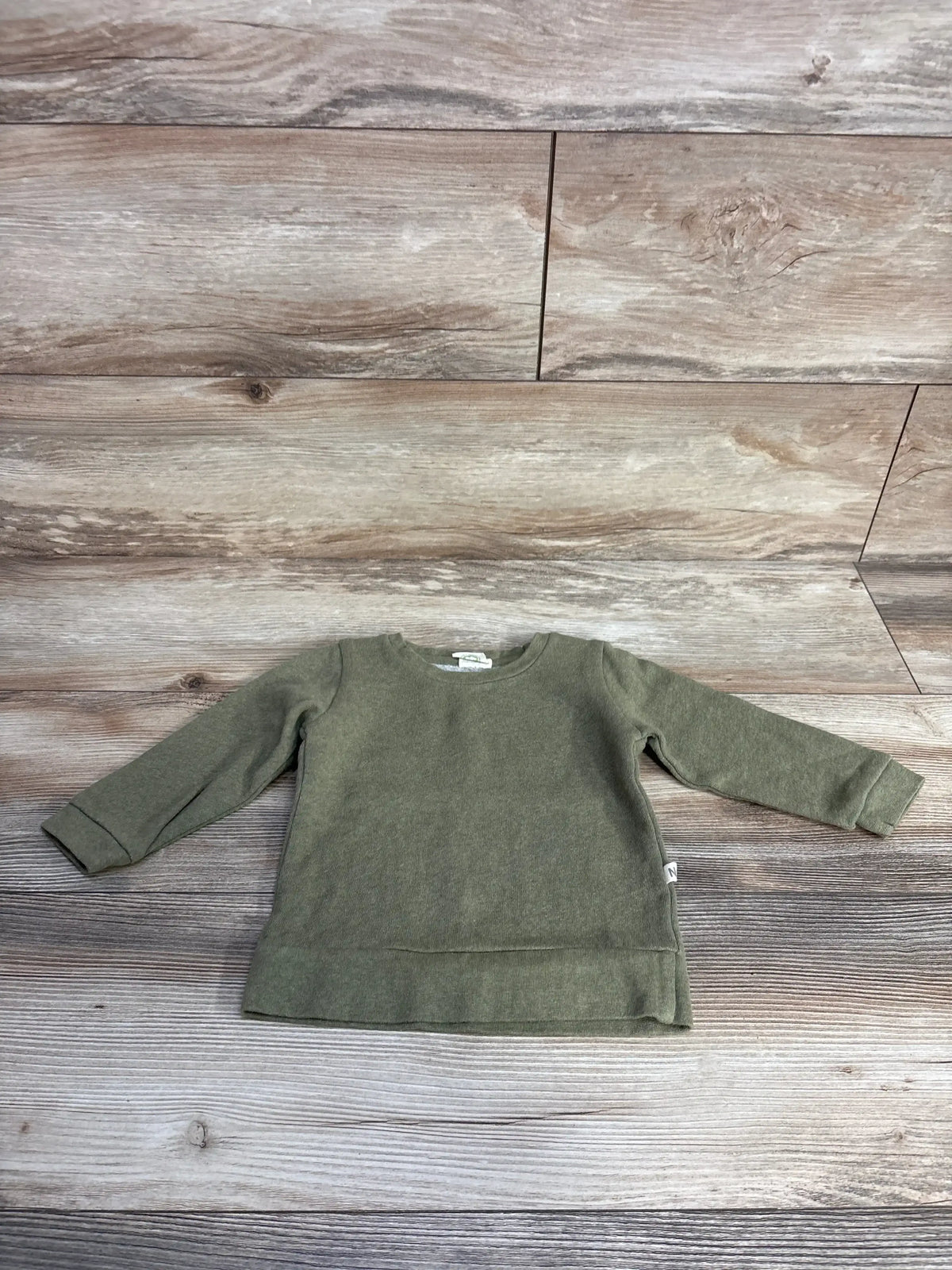 olive green long sleeve toddler sweatshirt on wood plank floor background