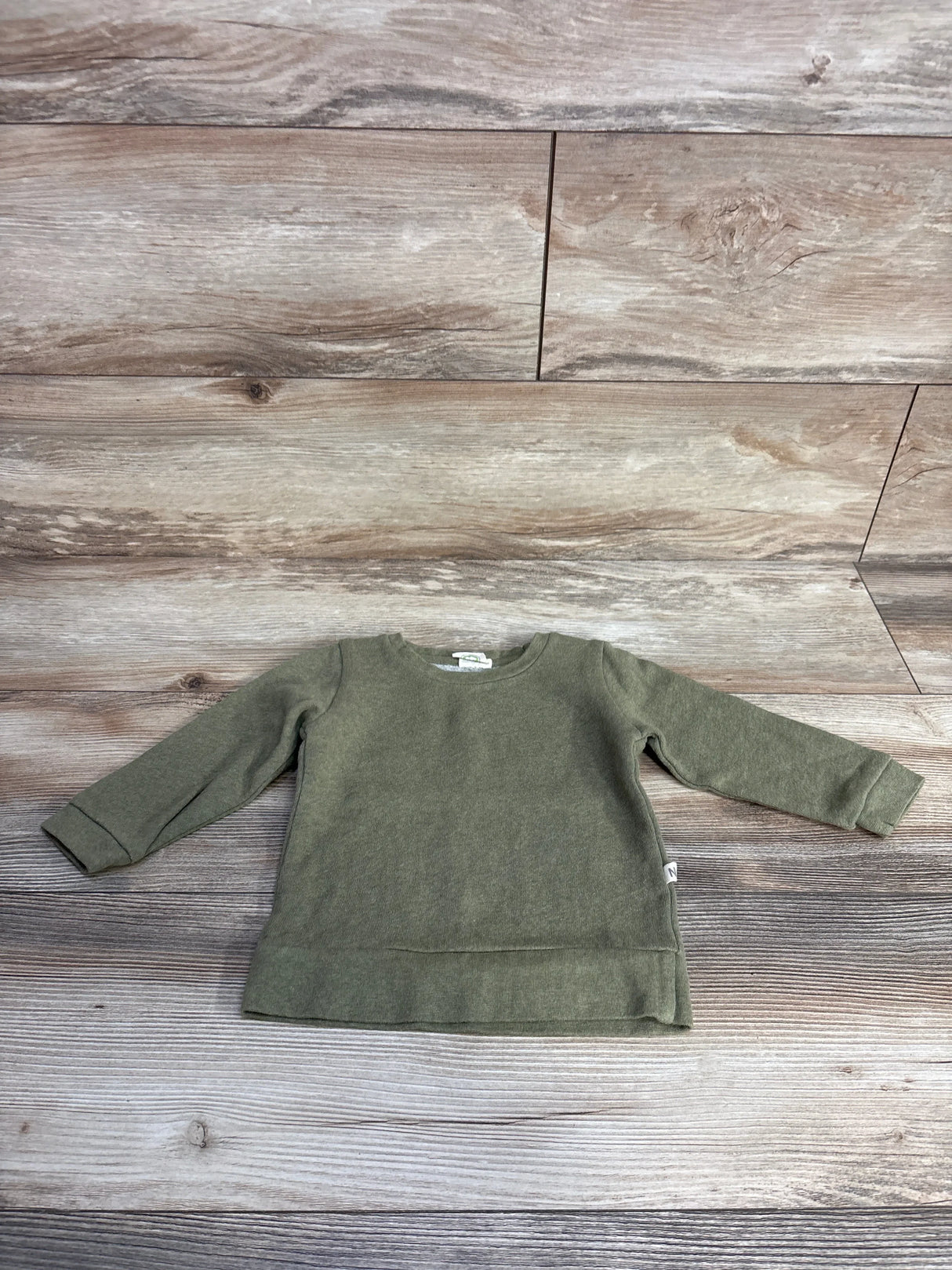 olive green long sleeve toddler sweatshirt on wood plank floor background