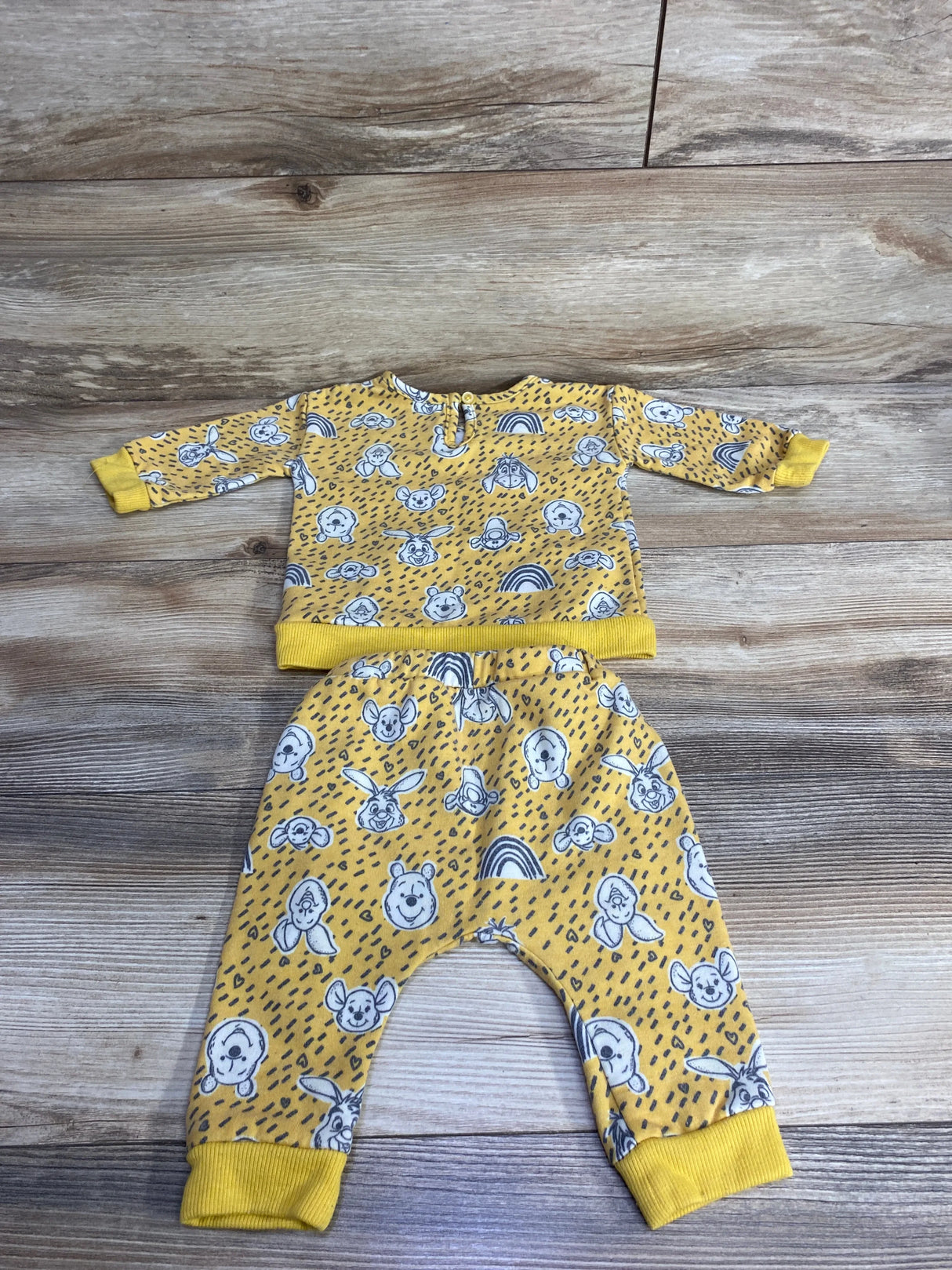 Yellow toddler outfit with long-sleeve top and pants featuring cartoon bear, bunny faces, and rainbow prints