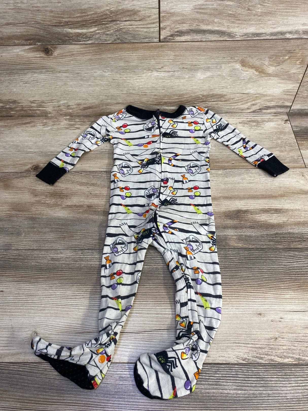 Halloween-themed baby footed pajamas with candy and spider print, perfect for kids' sleepwear