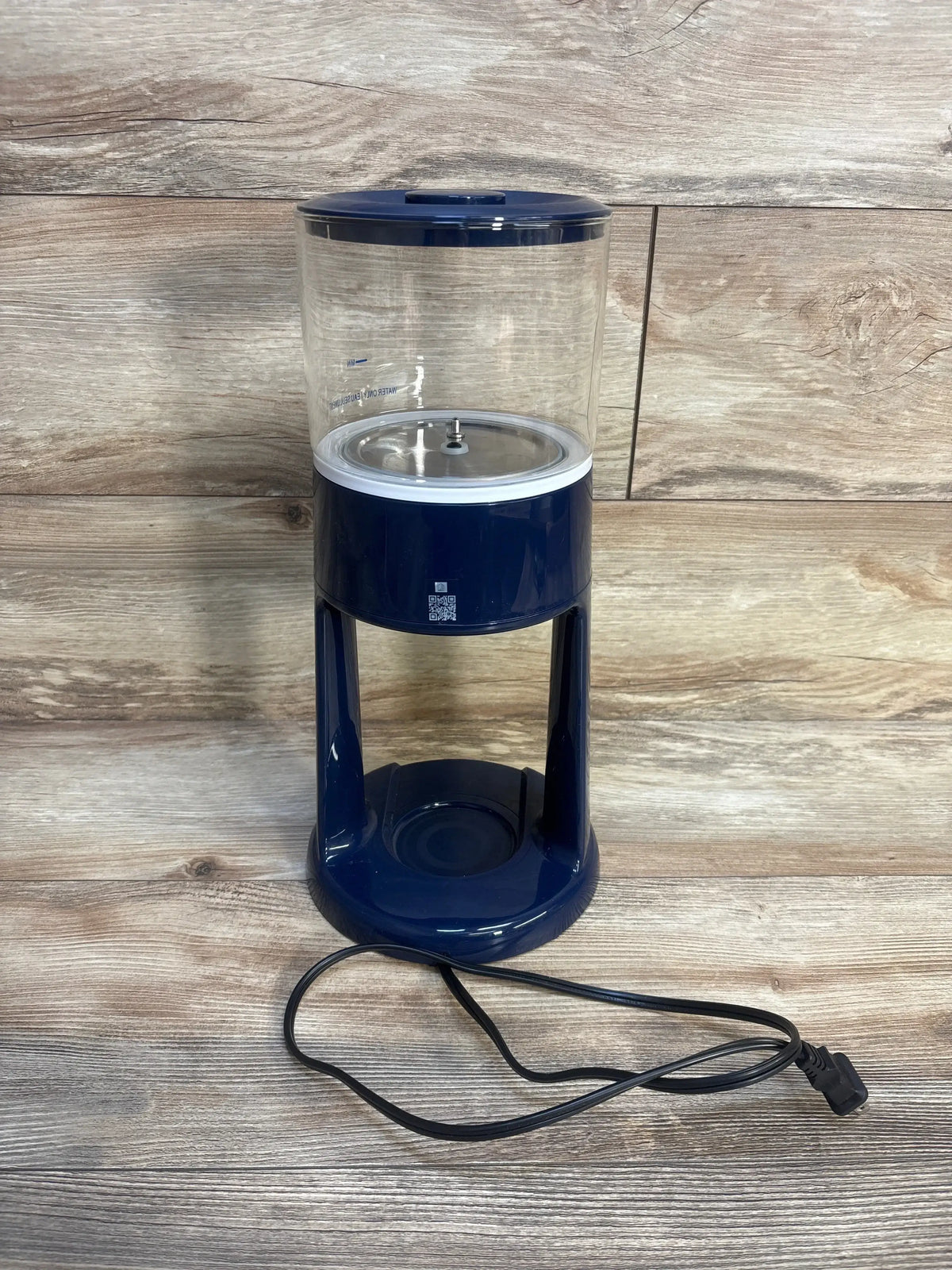 Front view of Dr. Brown’s Insta-Prep Warm Water Dispenser showing clear water chamber and navy base on wood background