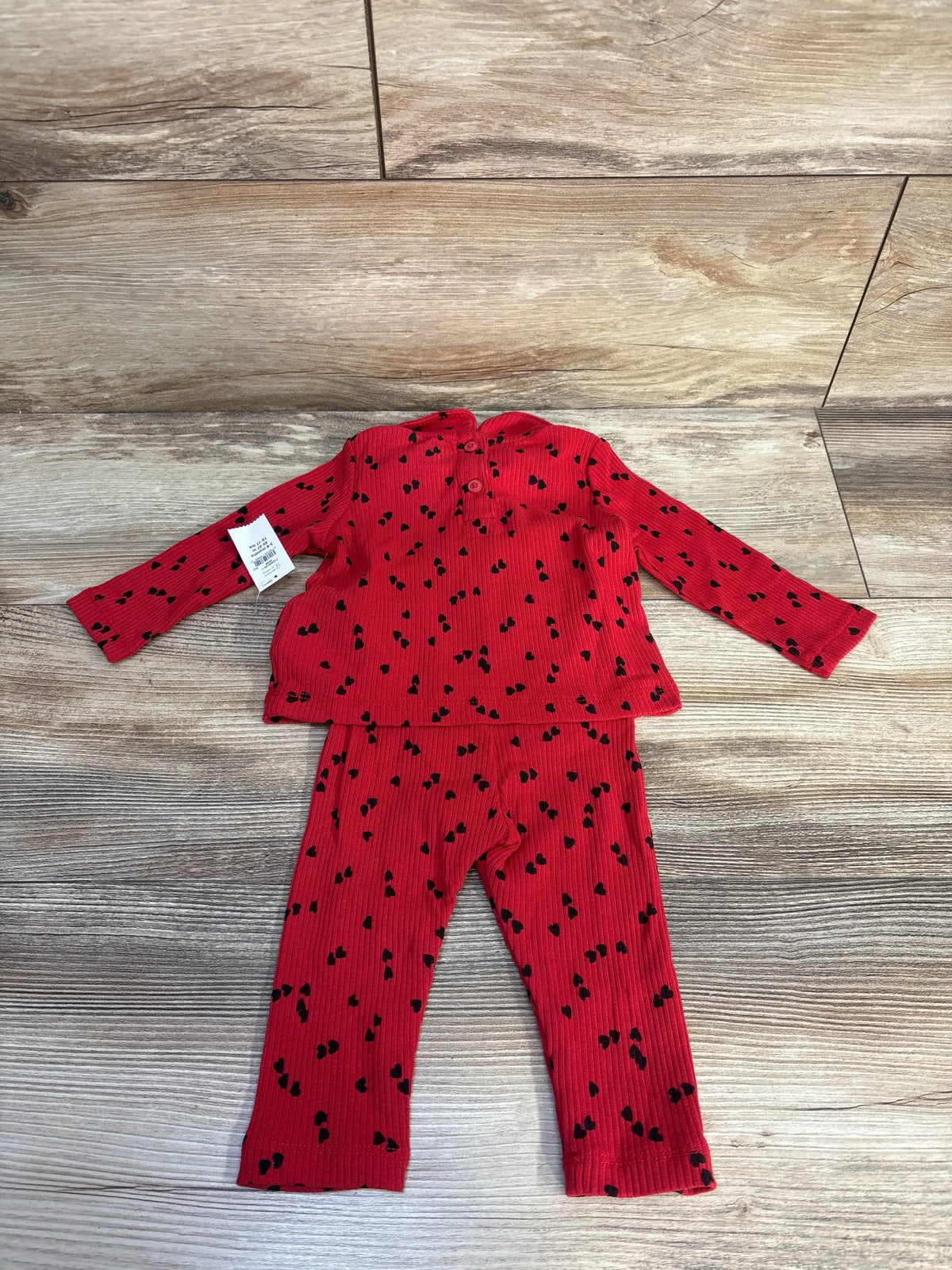 Flat lay of red ribbed Baby Gap shirt and pants set showcasing black heart print and Peter Pan collar
