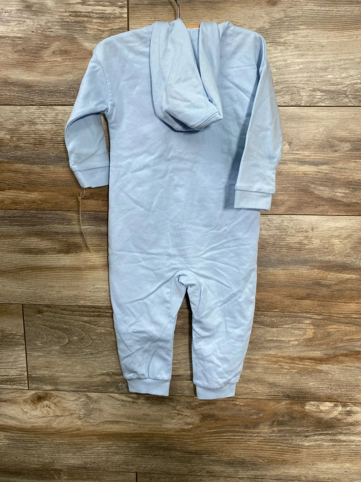 Back view of light blue Levi's hooded baby coverall, size 18M, with cuffed ankles on wood background