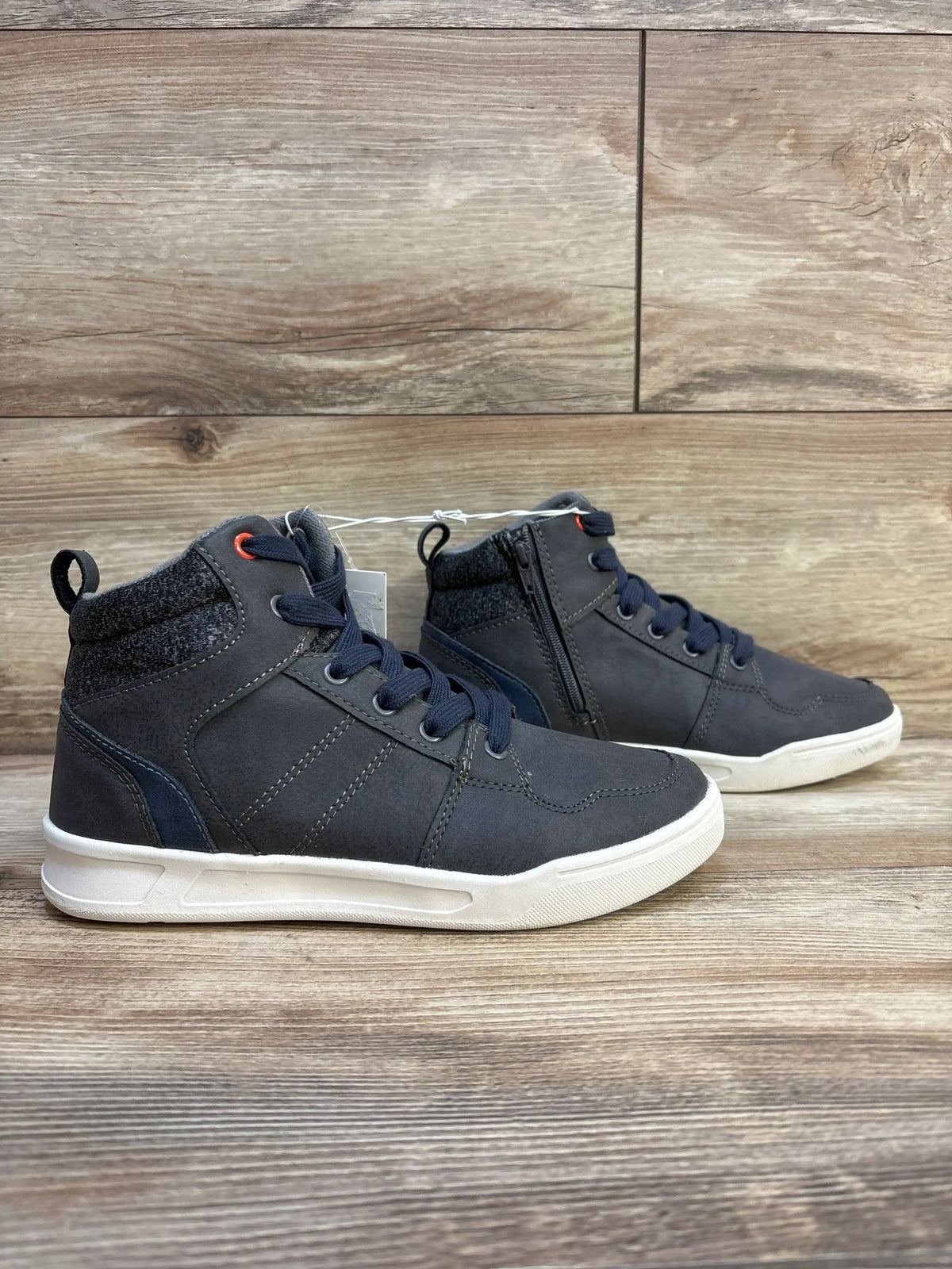 Kids' navy blue high-top sneakers with white soles and zipper, displayed on wooden background