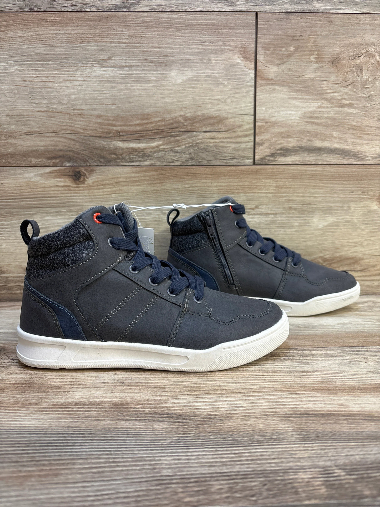 Kids' navy blue high-top sneakers with white soles and zipper, displayed on wooden background