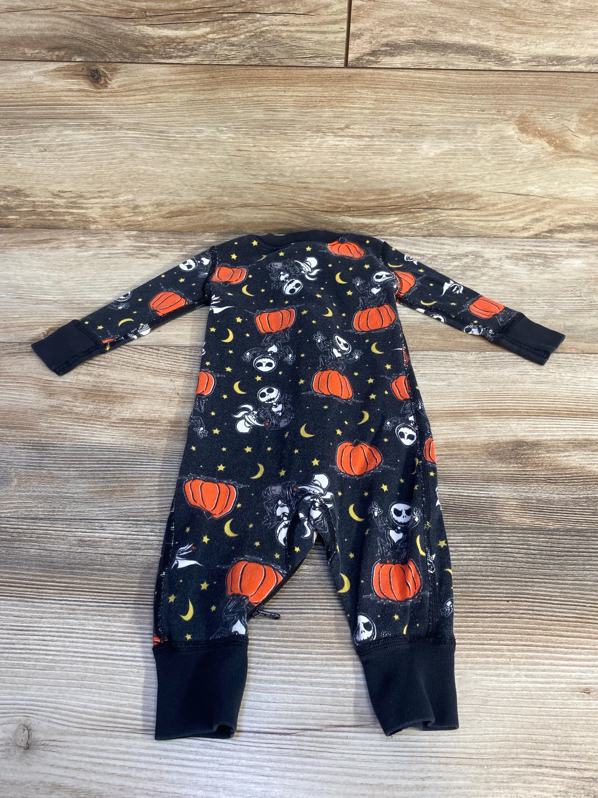 Halloween-themed baby onesie with pumpkins, moons, and stars on black fabric