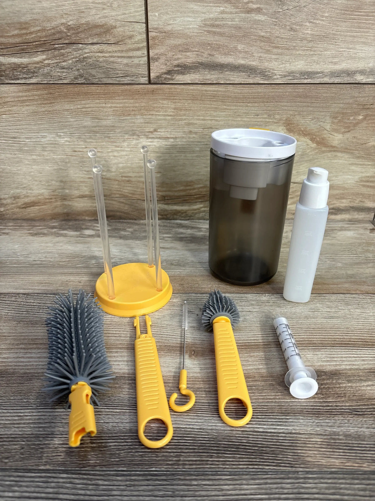 Front view of JoviKids 6-in-1 Portable Bottle Brush Set showcasing bottle, straw, and nipple cleaning tools on a wood surface