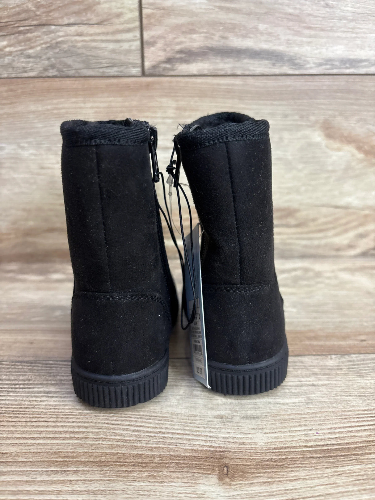 Rear view of Cat & Jack Pip Shearling Style toddler boots in black size 5C showcasing soft ribbed soles on wood floor