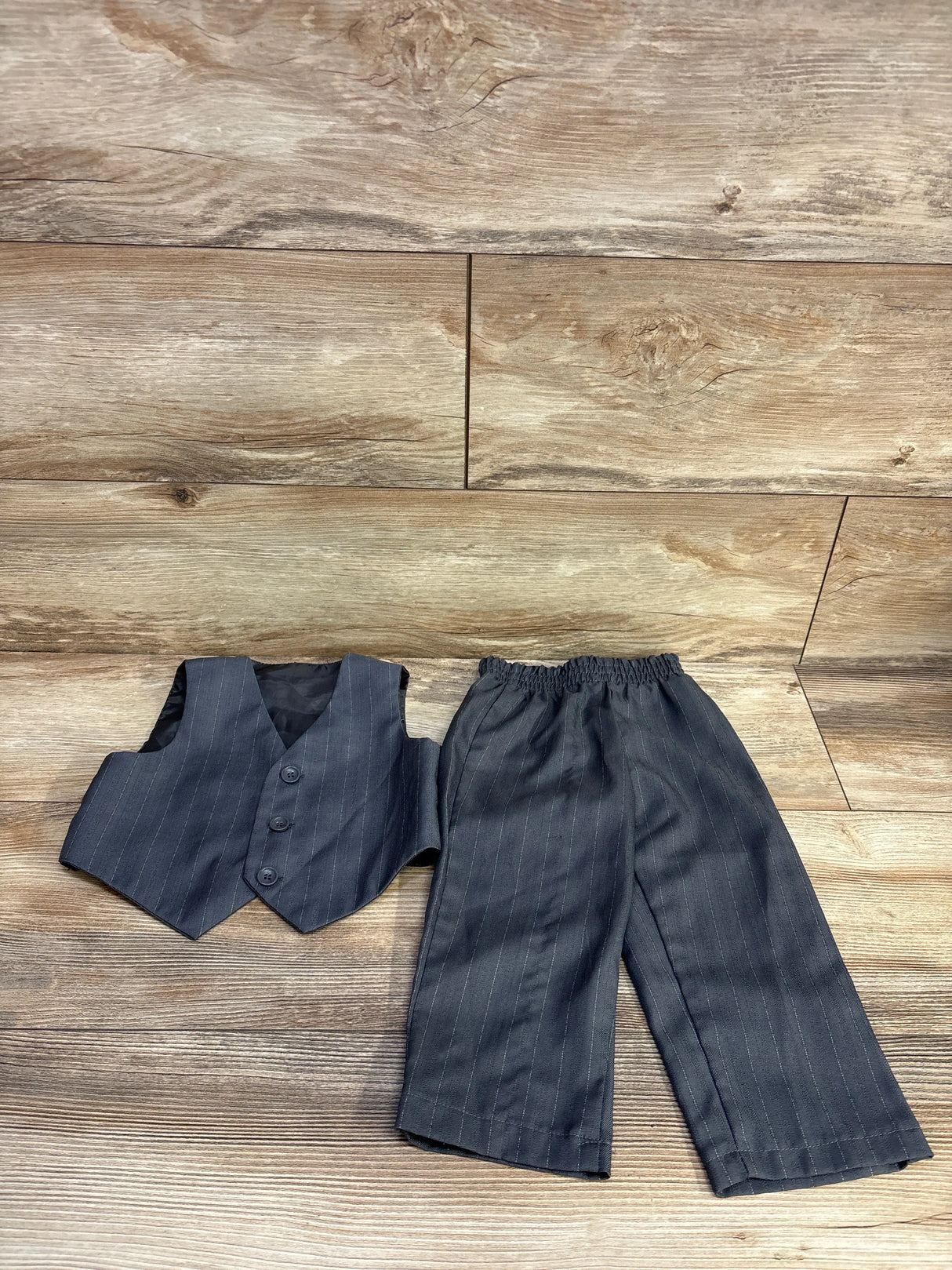 Children's pinstripe vest and pants suit set on wood background