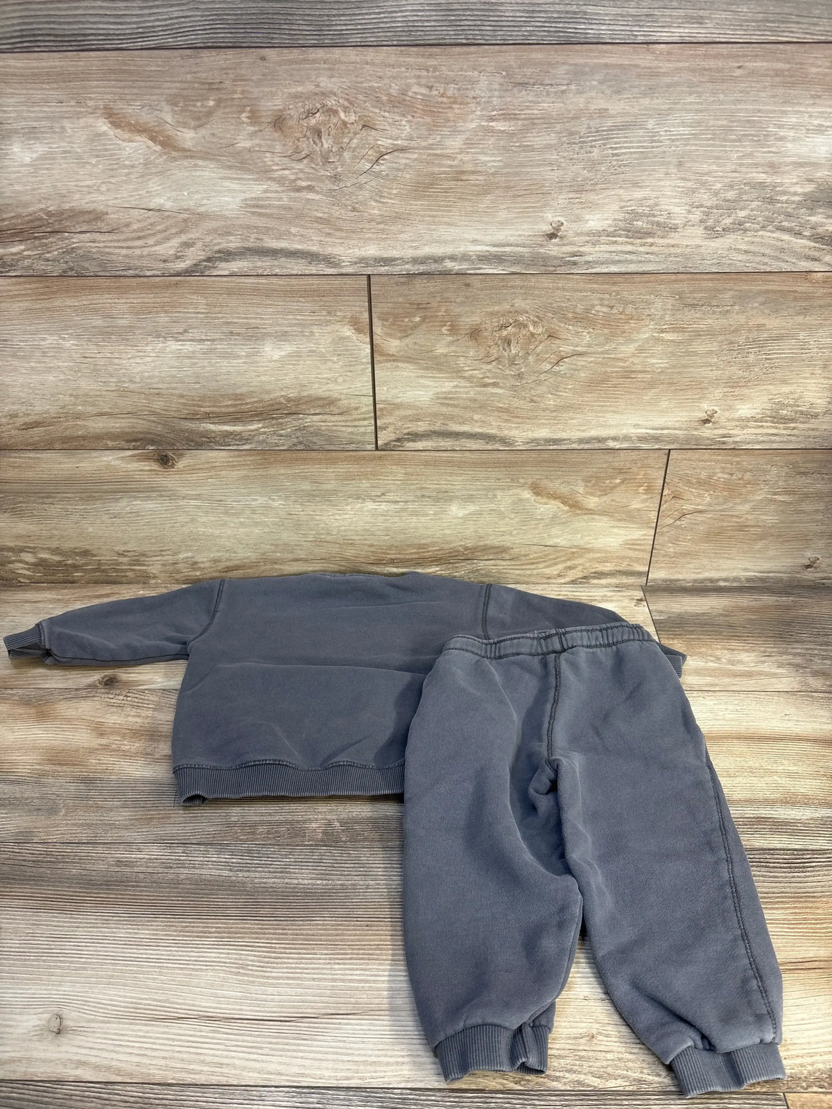 Gray kids sweatshirt and jogger pants set on wood floor, cozy toddler clothing