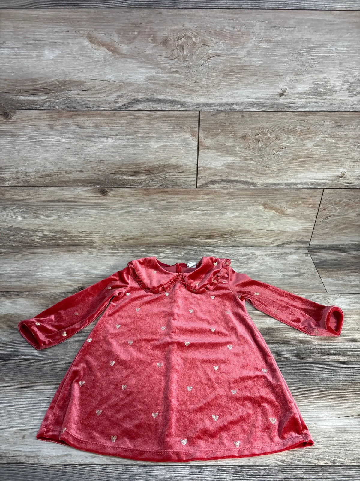 Red velvet baby dress with long sleeves, ruffled collar, and small silver heart patterns