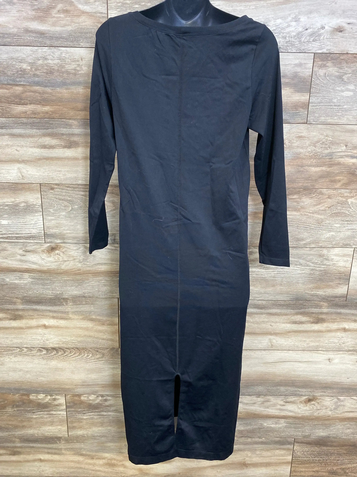 Back view of Isabel maternity long sleeve dress, black size XL, showing center back seam and hem slit on wood backdrop