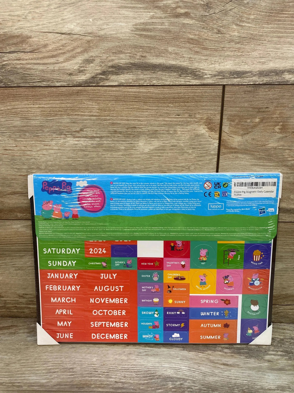 Front view of Peppa Pig magnetic daily calendar with removable tiles for days, months, weather and holidays on wood background