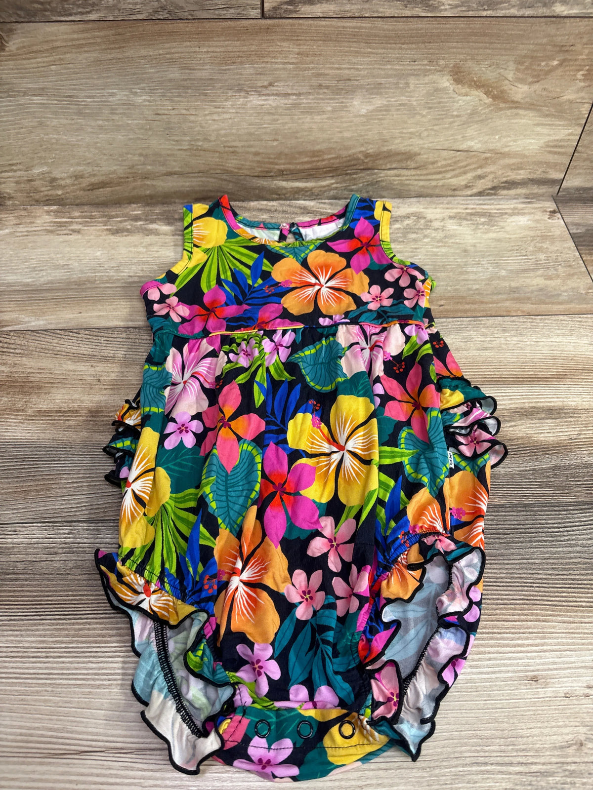 Front view of Play by Little Sleepies Jungle Blooms bubble romper in size 3T showcasing a colorful floral print on wood flooring