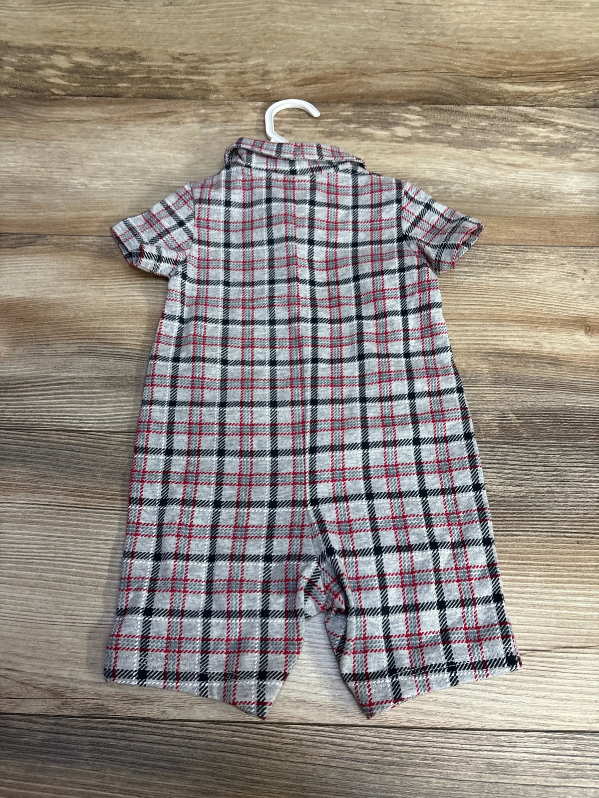 Back view of grey plaid baby romper (3-6M) showing short sleeves, foldover collar and snap crotch on wooden floor background