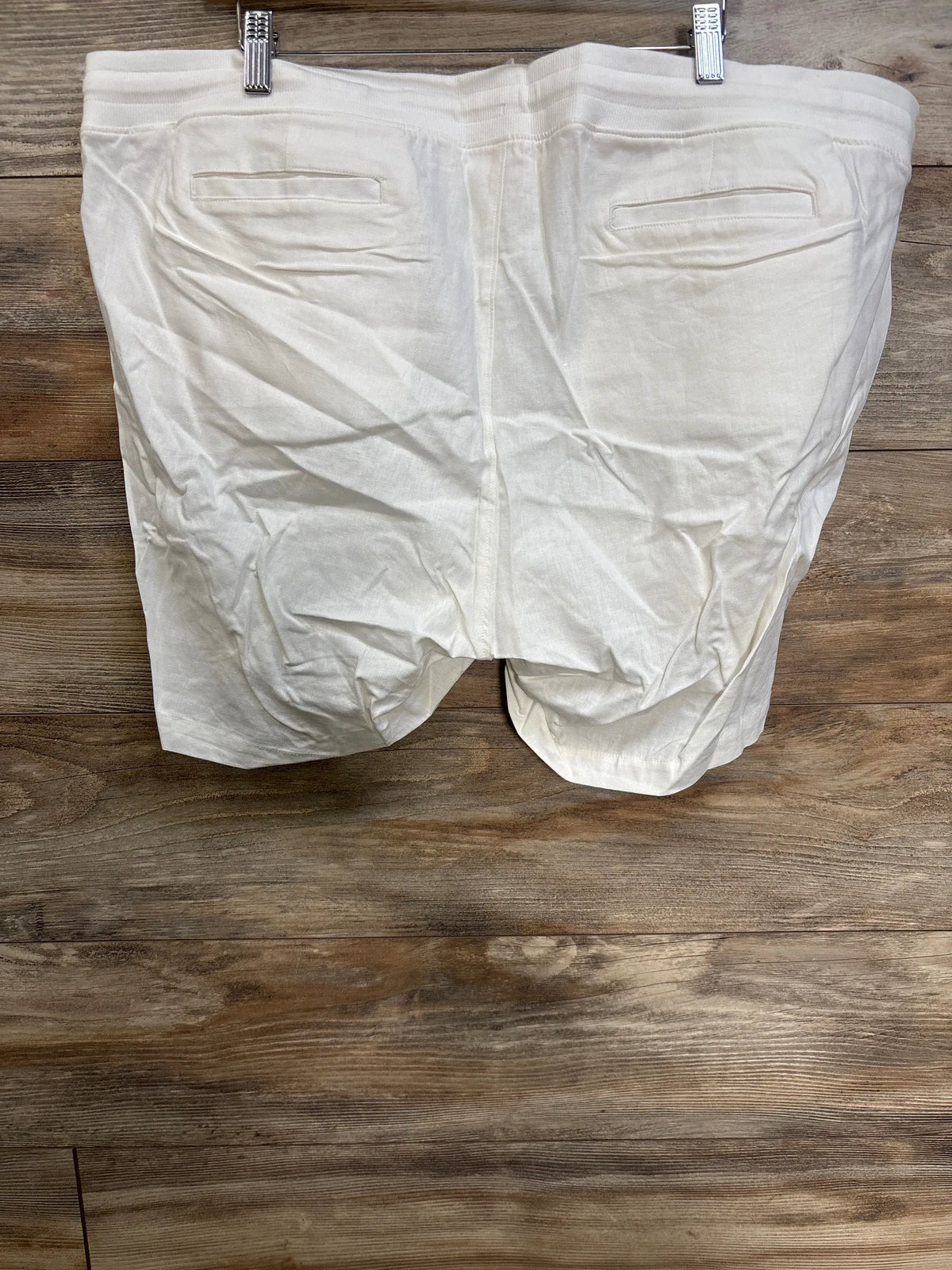 Back view of white Gap maternity linen-blend shorts on a wooden background