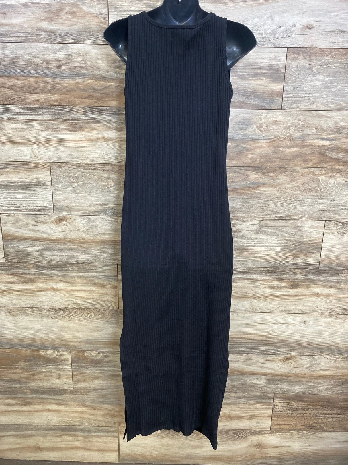 Front view of black ribbed maternity maxi dress showing sleeveless crew neckline and fitted silhouette on wood background