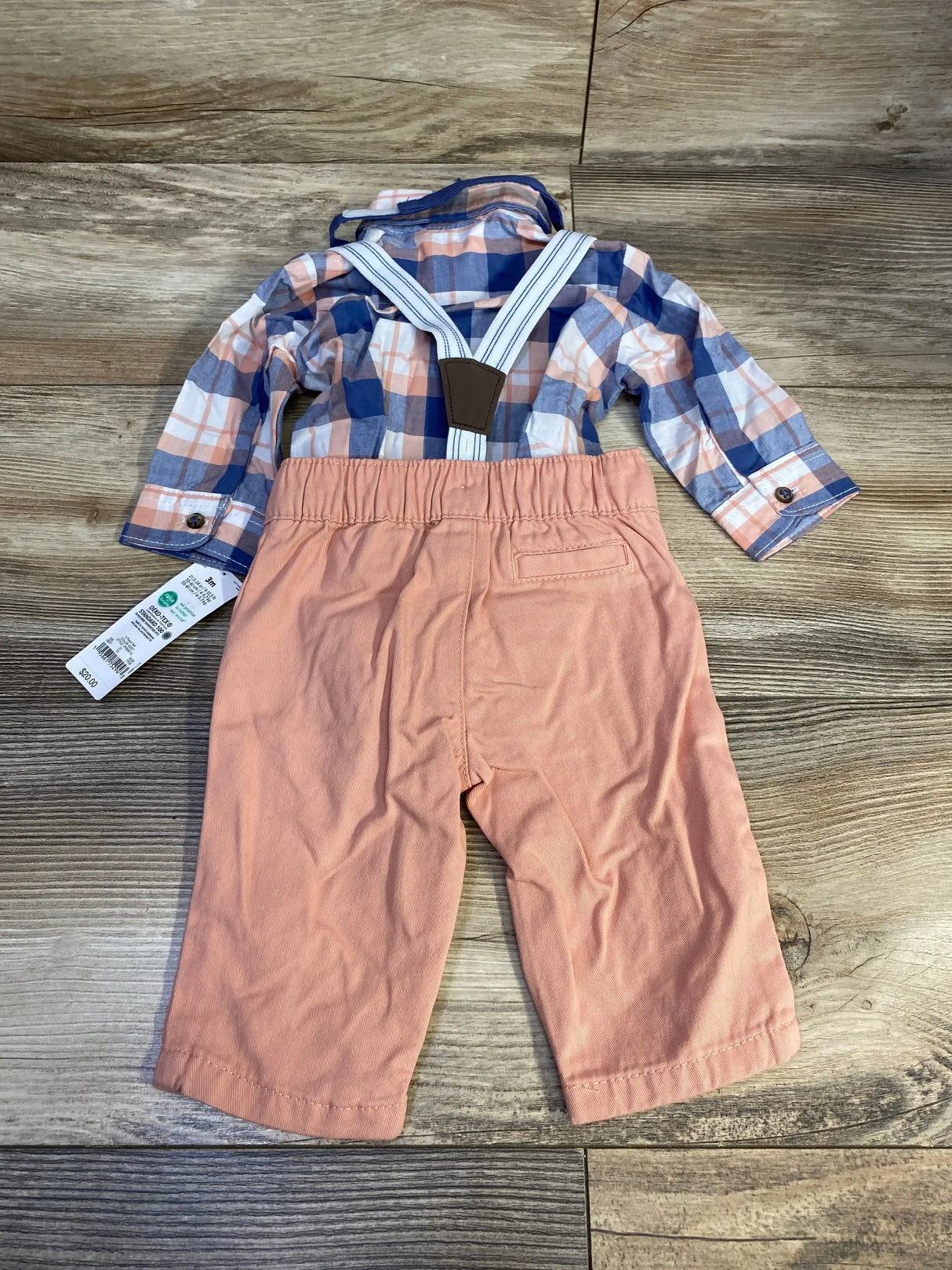 Flat lay of NEW Just One You four piece set with blue and peach plaid button up shirt salmon pants and suspenders on wood plank floor