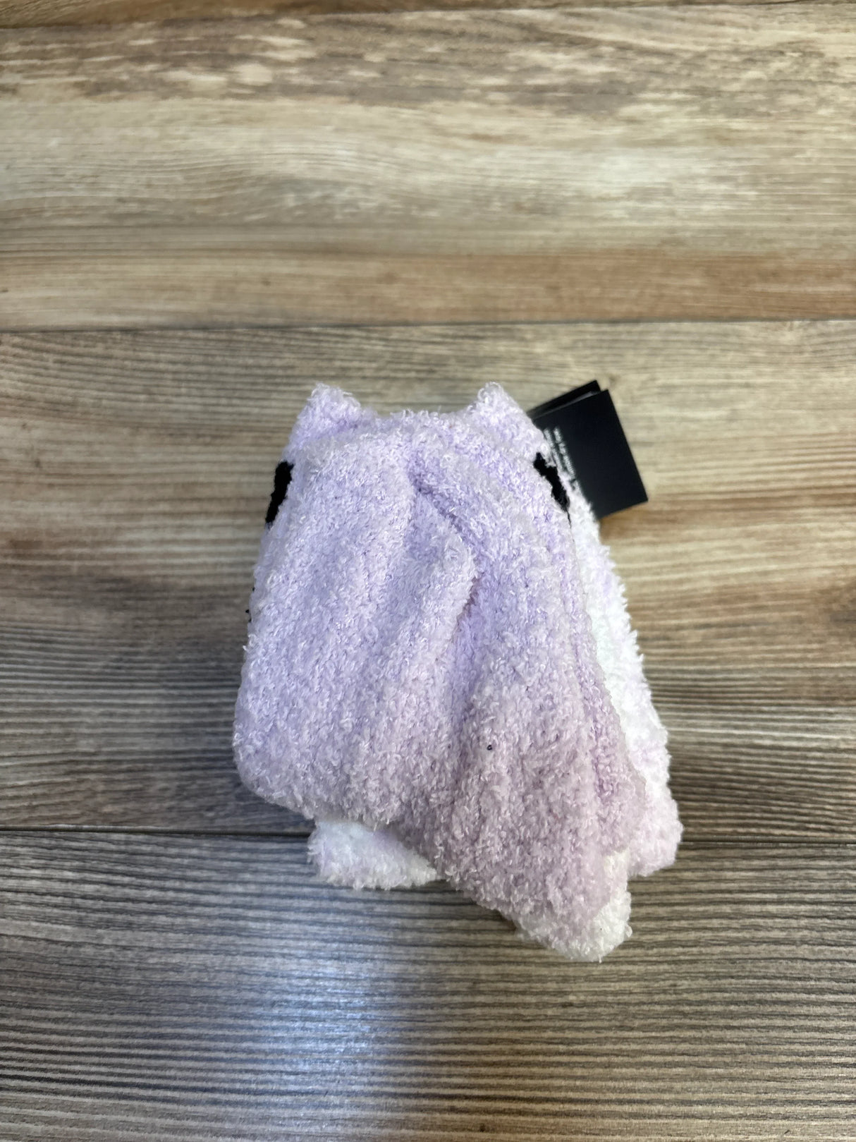 Purple and white plush animal washcloth for kids on wooden surface