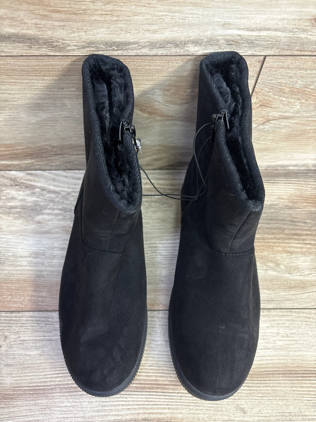 Top view of Cat and Jack Holland Shearling Style Boots in black showcasing faux fur lining side zip and hangtag on wood plank floor