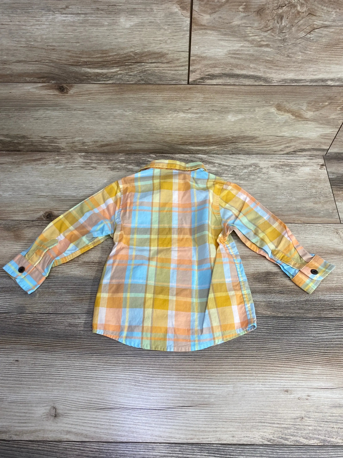 Back of Cat and Jack button-up toddler shirt 18 months showing yellow orange blue plaid and long sleeves on wooden floor