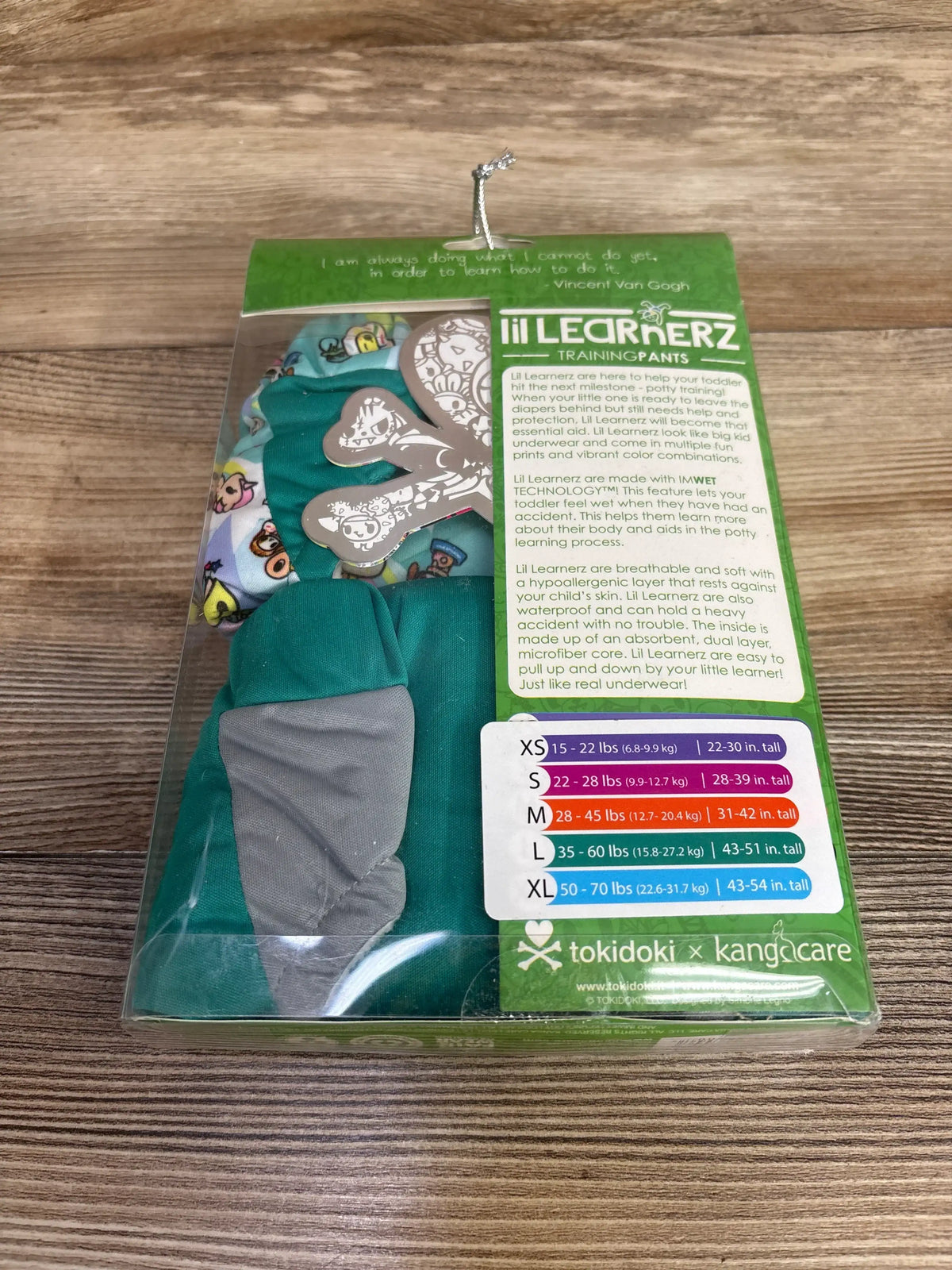 Lil Learnerz training pants in packaging with size chart, colorful prints, wooden background