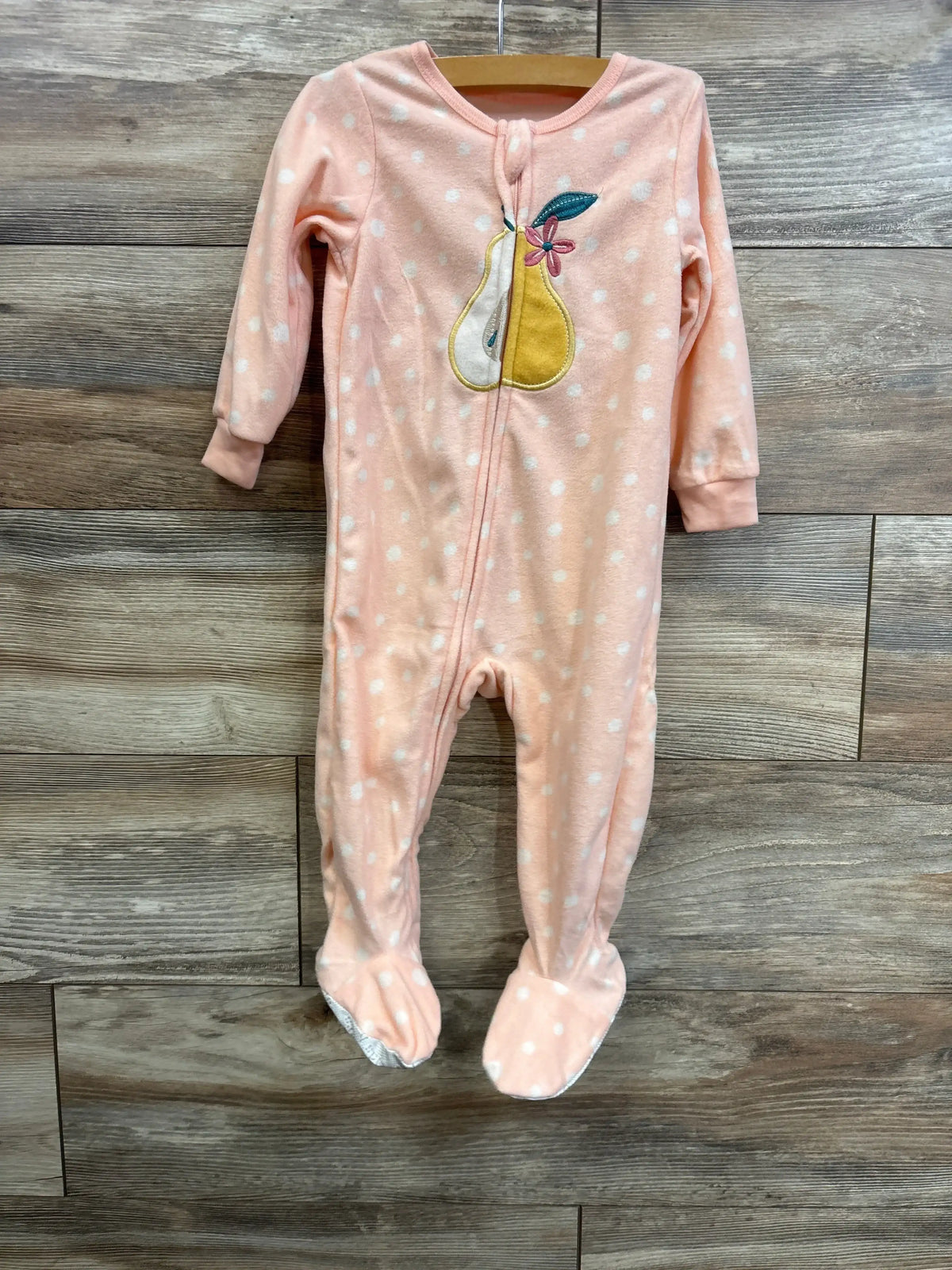 Front view of pink 18-month blanket sleeper with white polka dots, pear applique, and center-front zipper on wood background