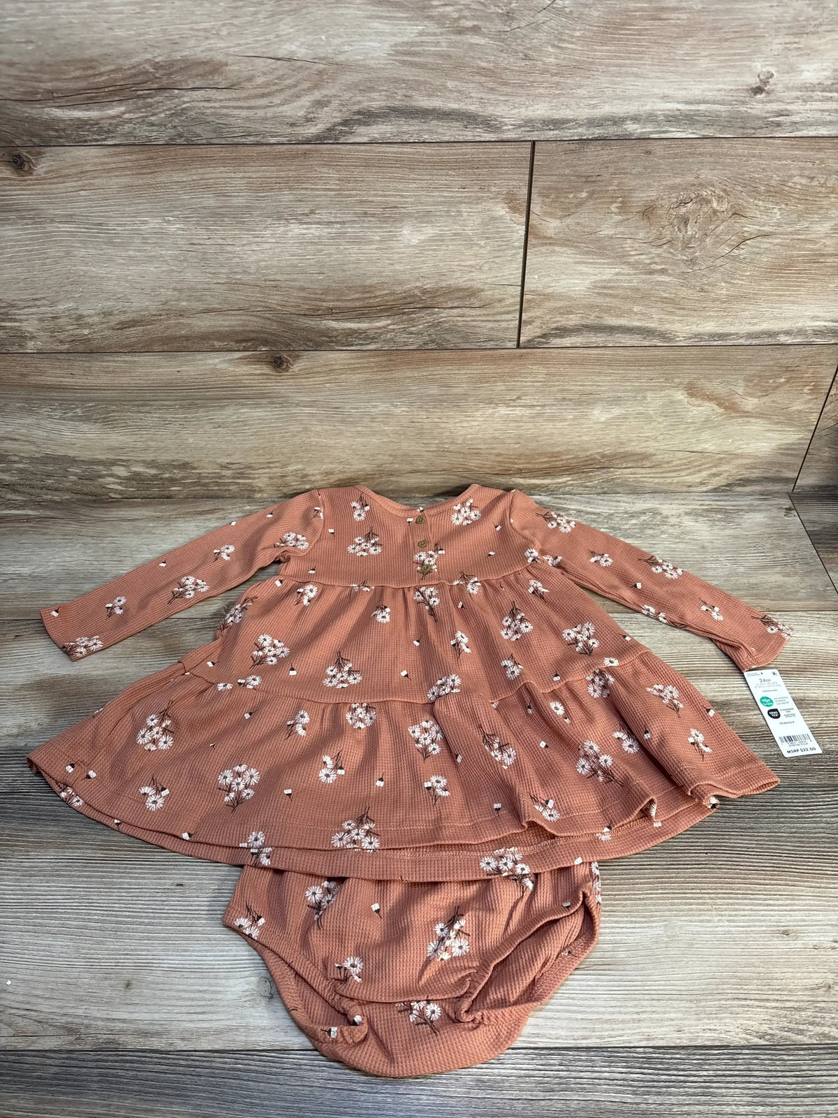 Rust floral long sleeve baby dress with matching bloomers on wood background
