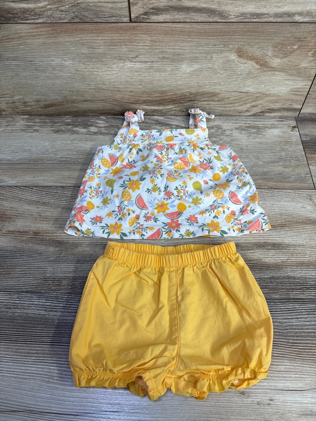 Front view of Just One You 2-piece tank top and shorts set showcasing a fruit-and-flower print and elastic-waist shorts on wood flooring