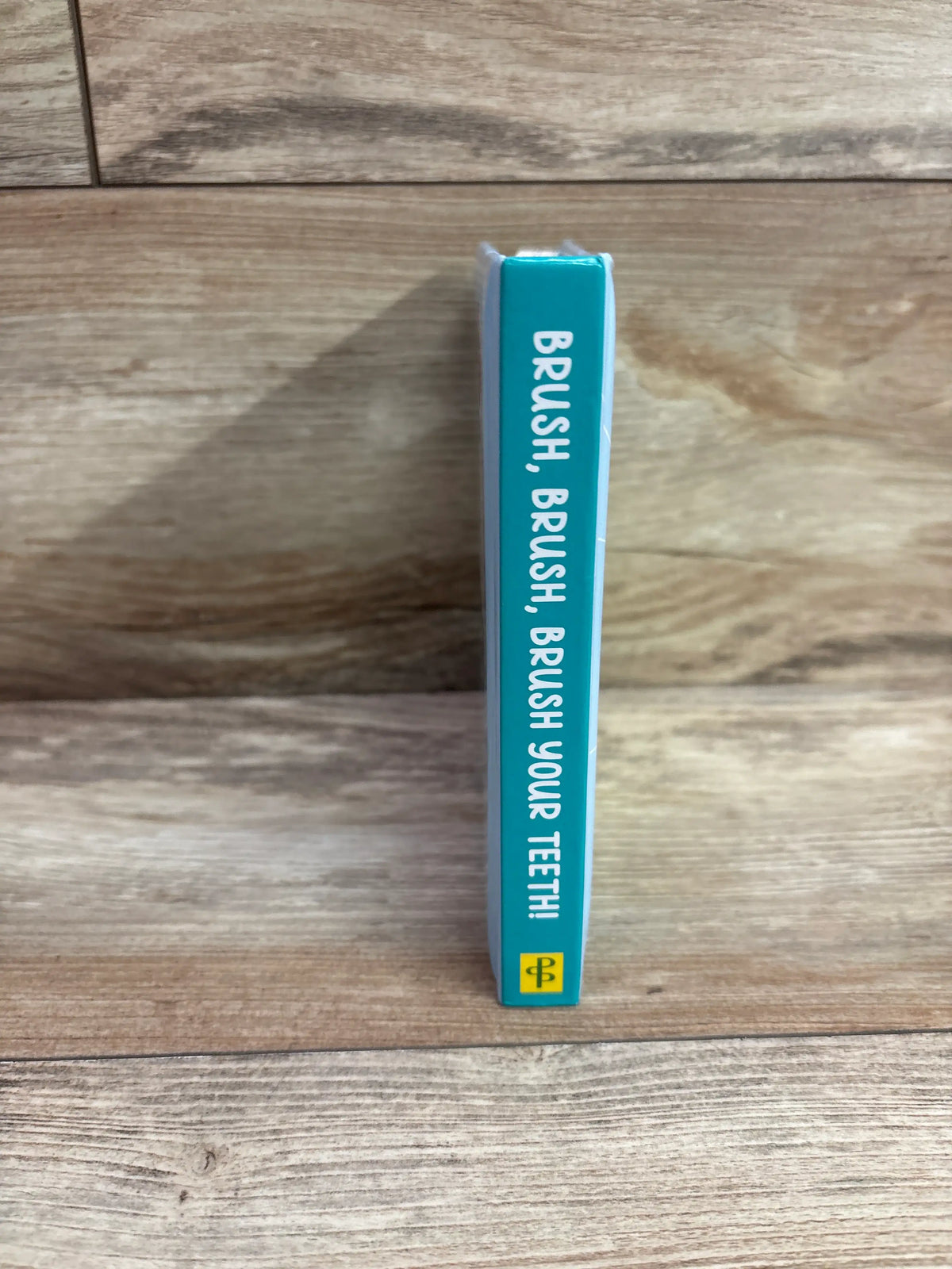 Spine of the 'Brush, Brush, Brush Your Teeth!' padded board book by Me n Mommy To Be.