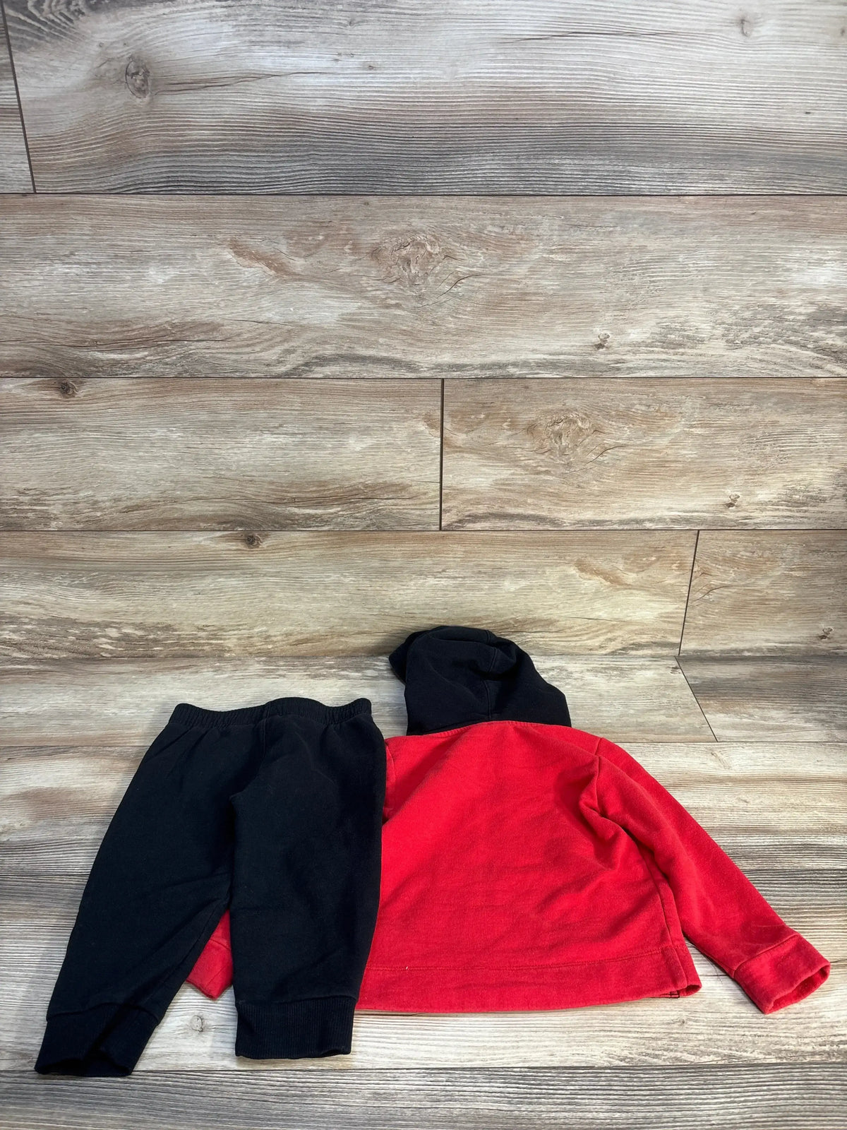 Red and black toddler hoodie with matching black pants on wood background