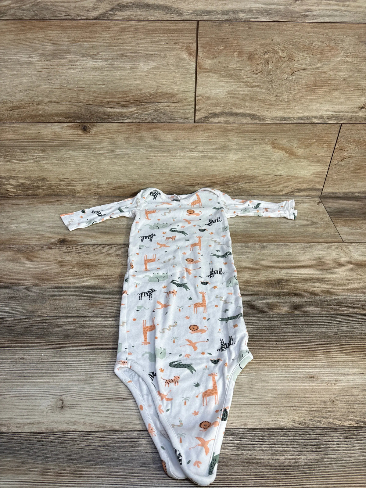 Top view of a white Nordstrom animal print knot gown showcasing long sleeves on a wood background