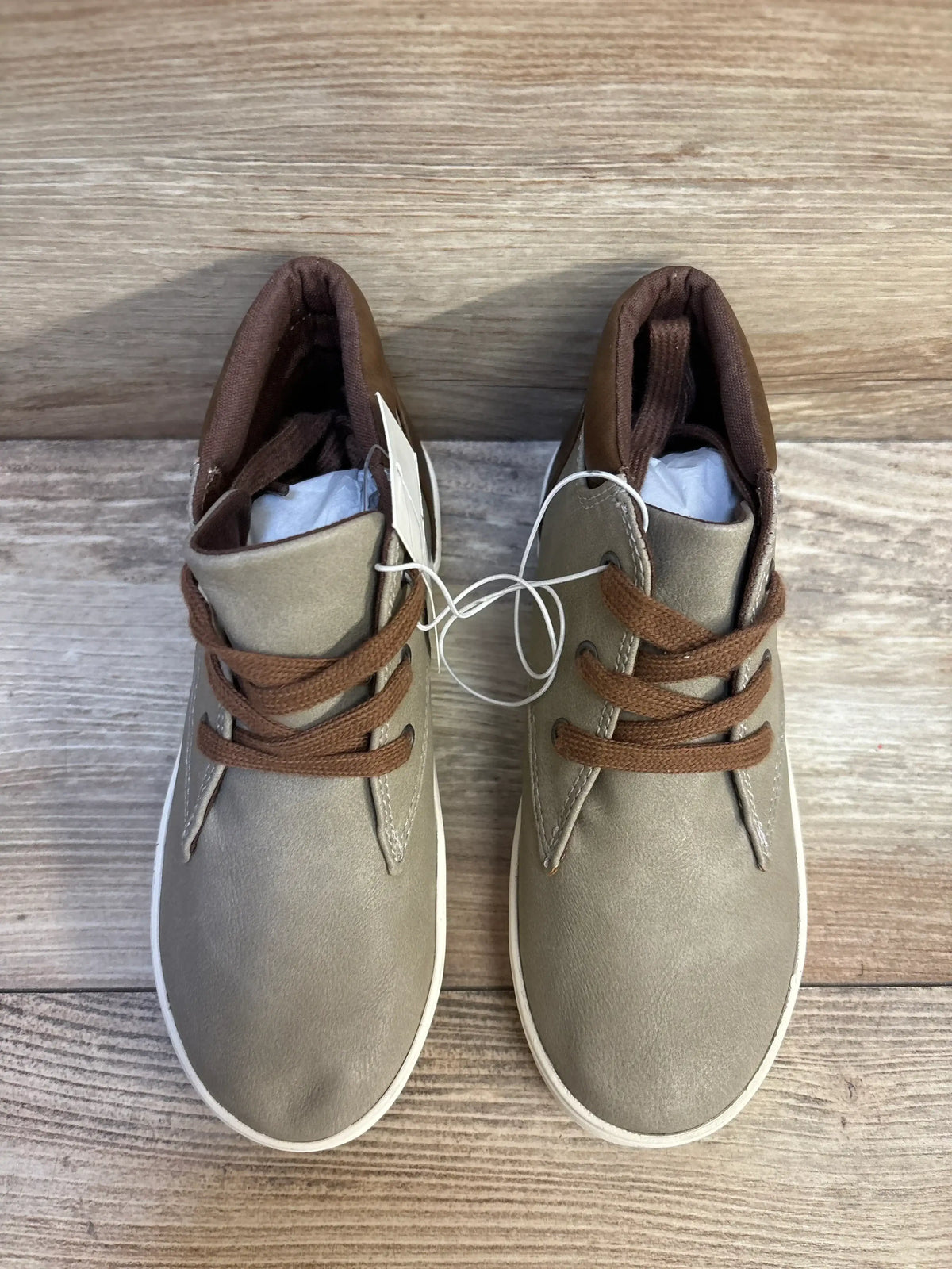 Top-down view of Cat & Jack Jakob toddler boots in grey showcasing brown laces and white soles on wood floor