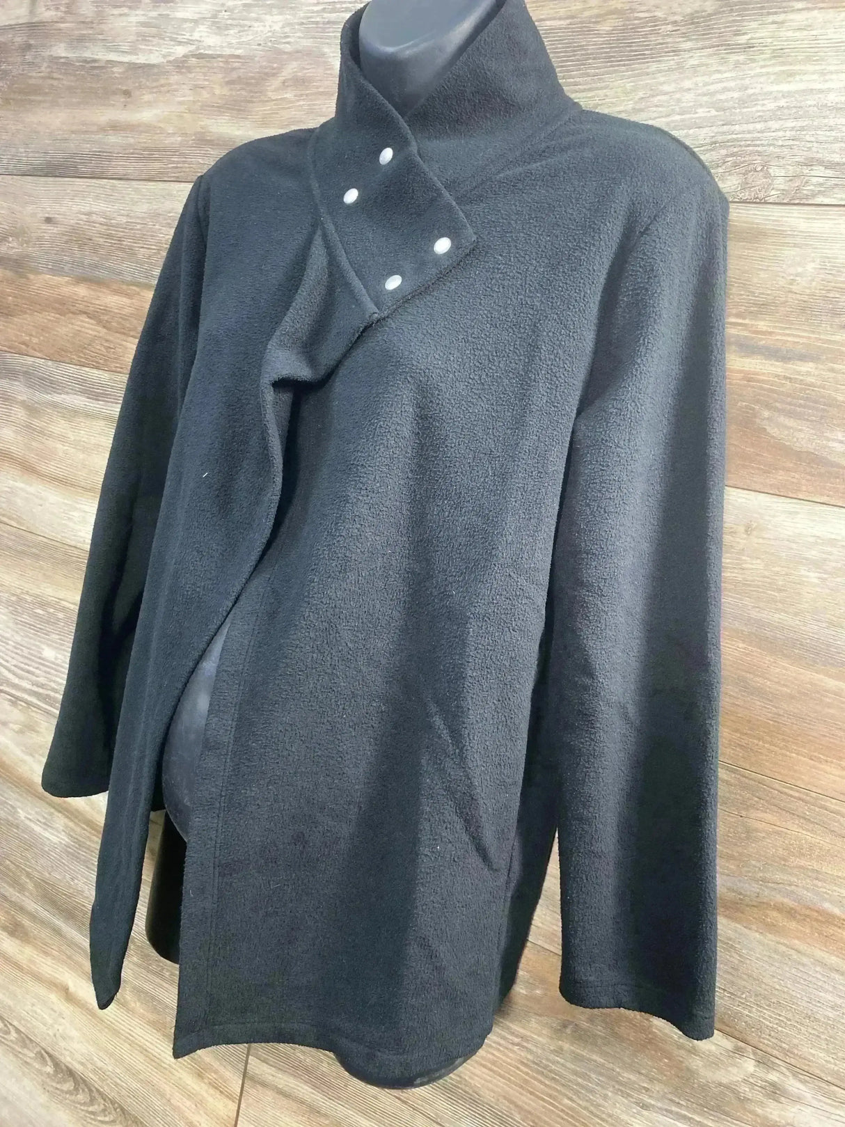 Front view of Gap maternity snap nursing sweatshirt in black with funnel neck and three snaps on wood background