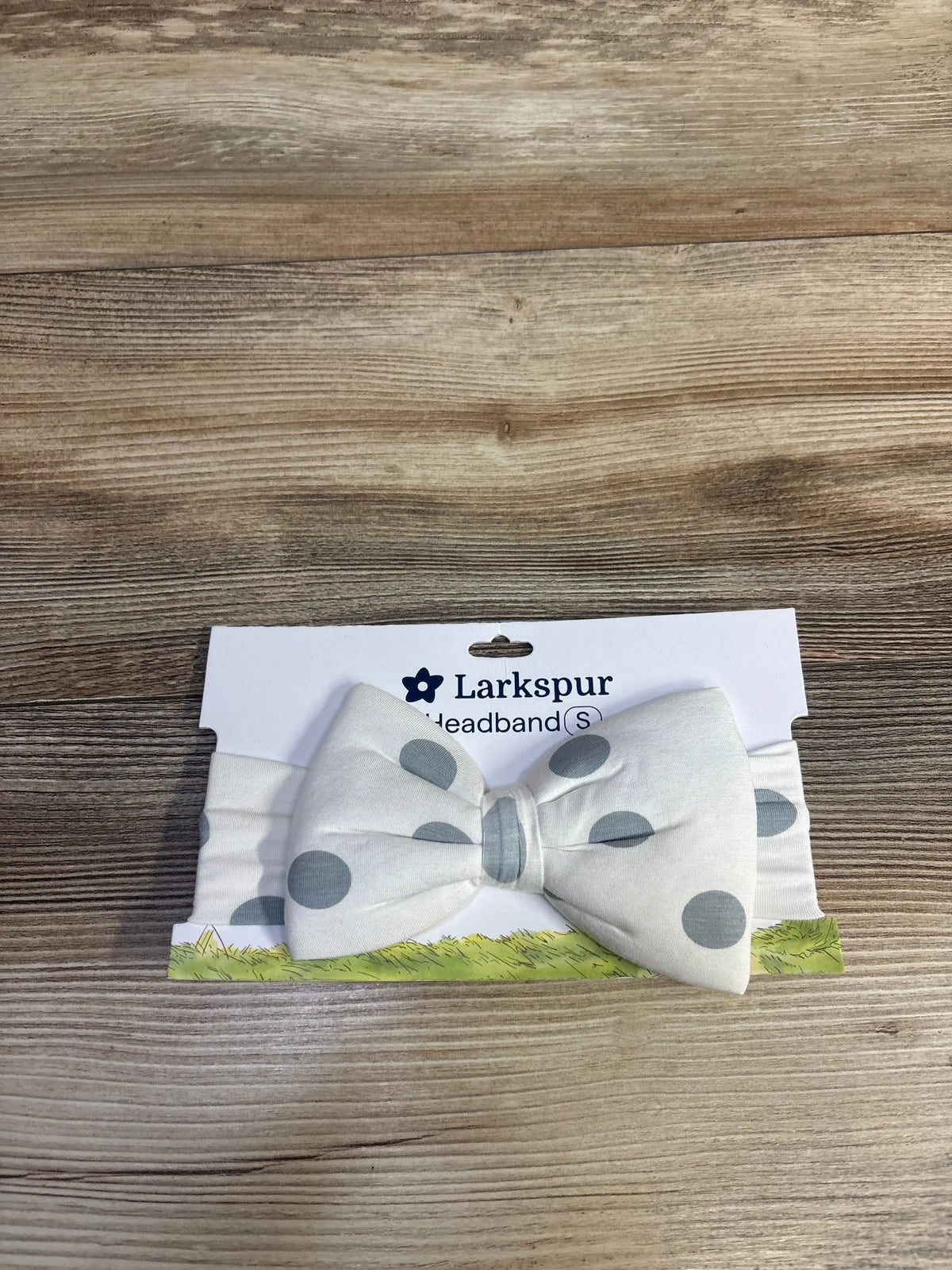 Front view of Larkspur polka dot bow headband in small size displayed on retail packaging
