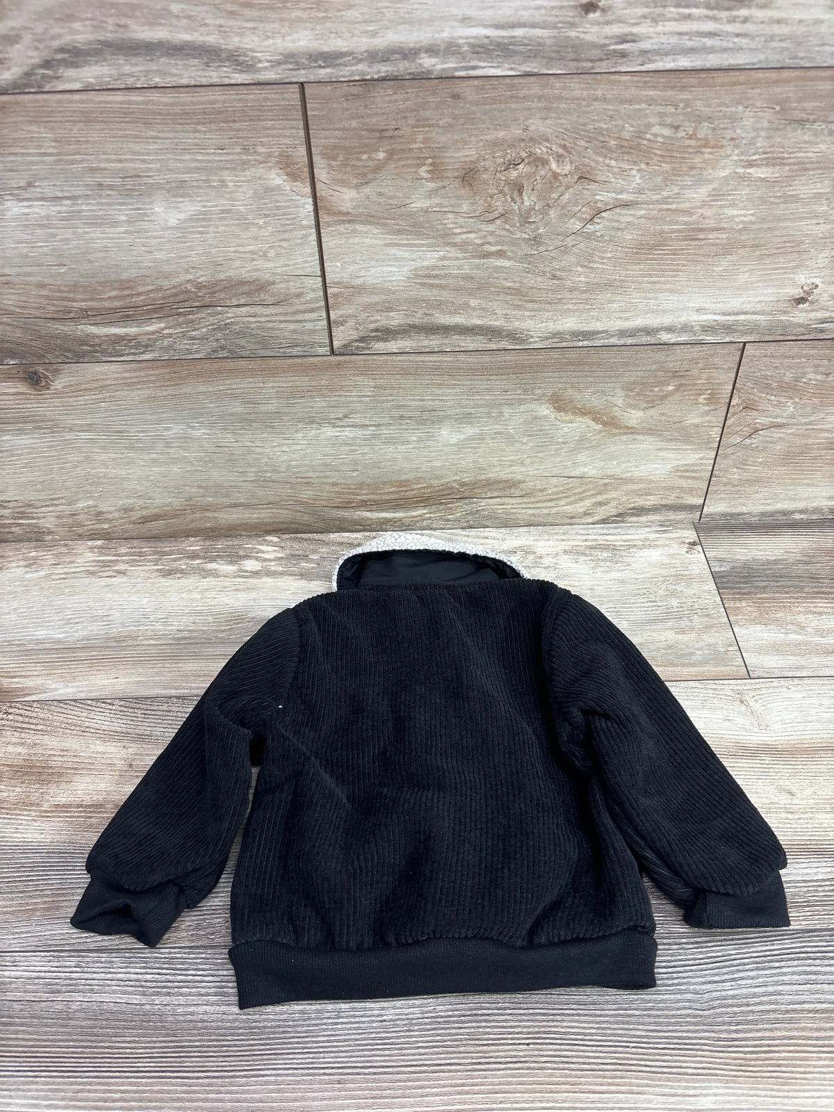 Back view of Shein black corduroy sherpa lined button up jacket size 9 to 12m showing ribbed texture and sherpa collar