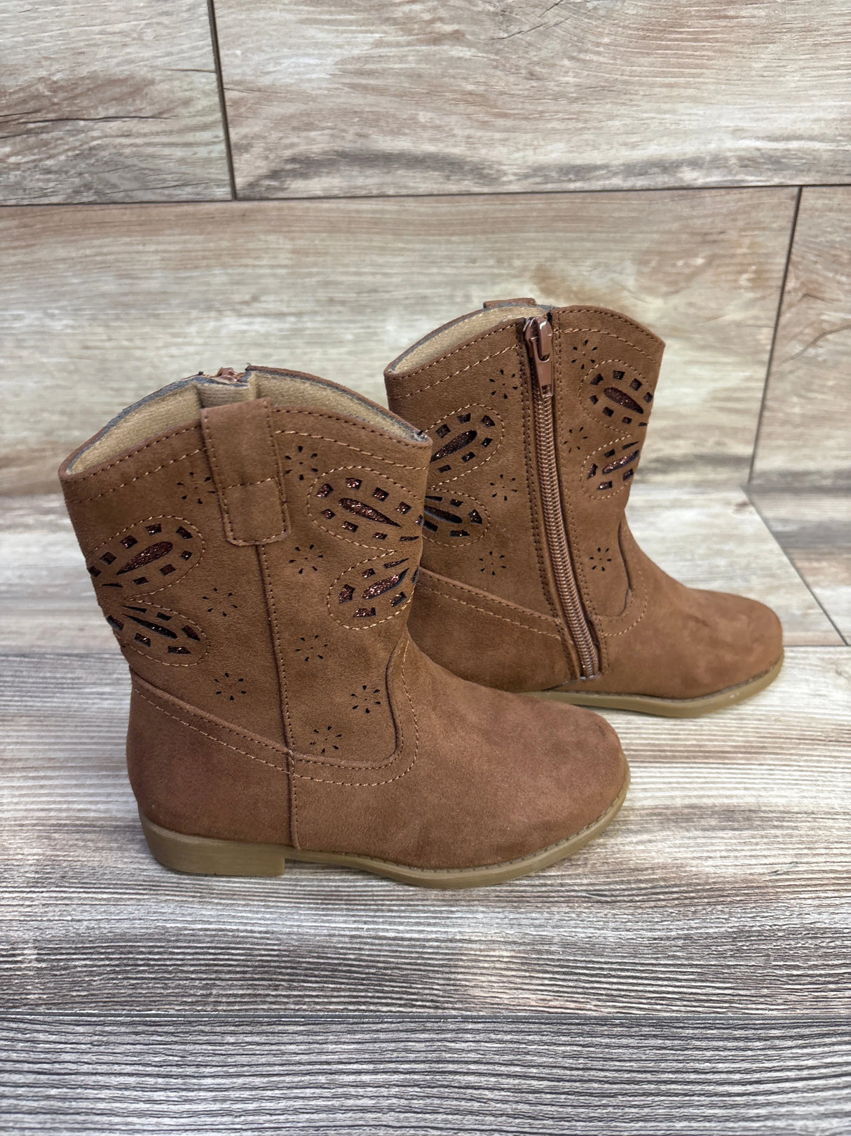 Side view of Lil Jayla toddler western boots in brown suede with side zipper and glitter cutouts on wood floor