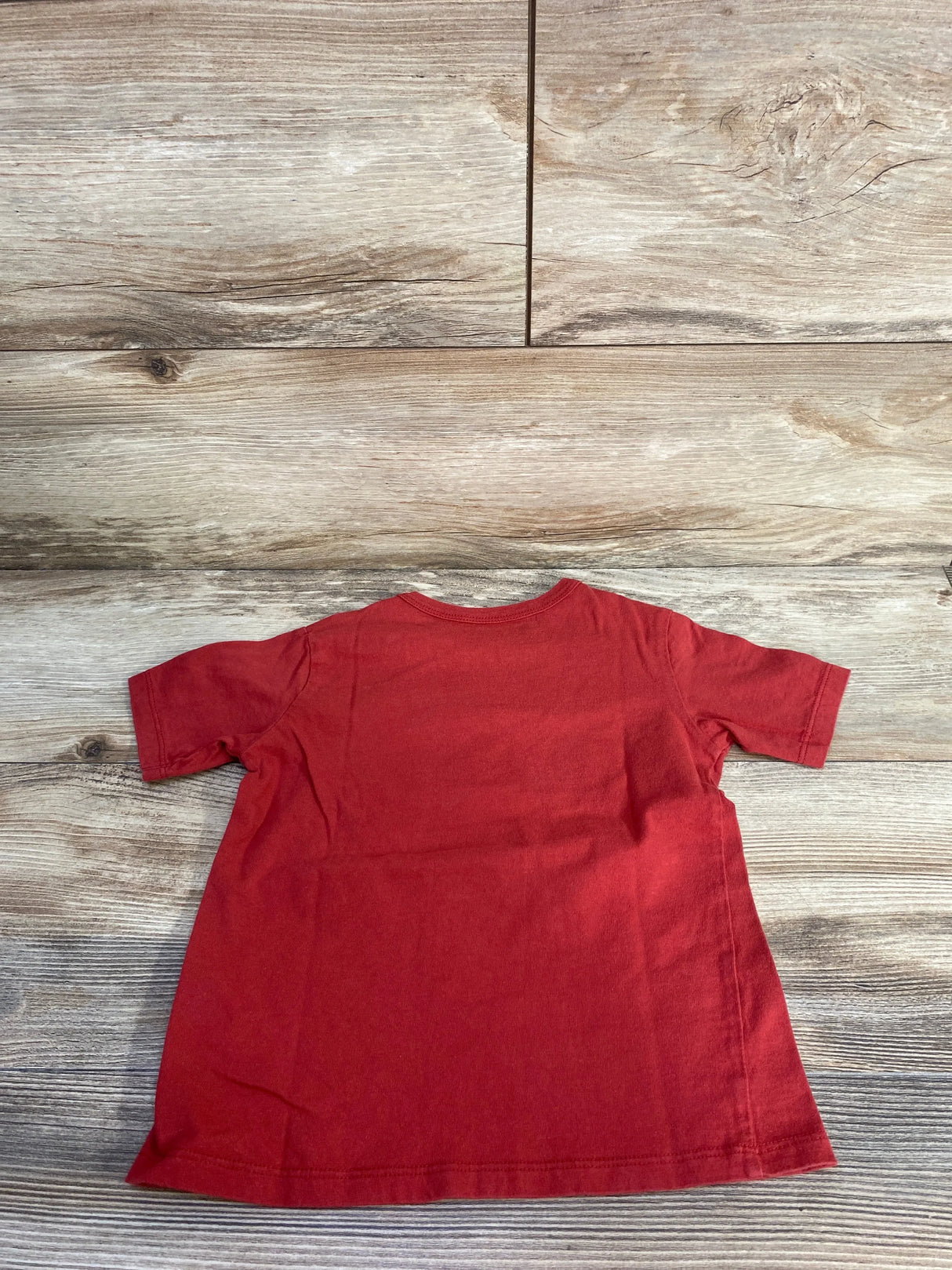 Back view of Children's Place red toddler T-shirt (4T) showing short sleeves and plain back on wood floor