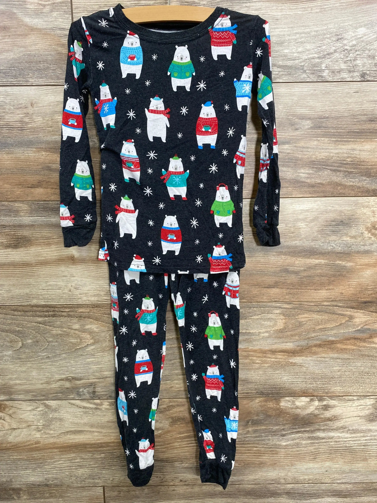 Kids' holiday polar bear pajamas with festive sweaters and snowflakes on dark background