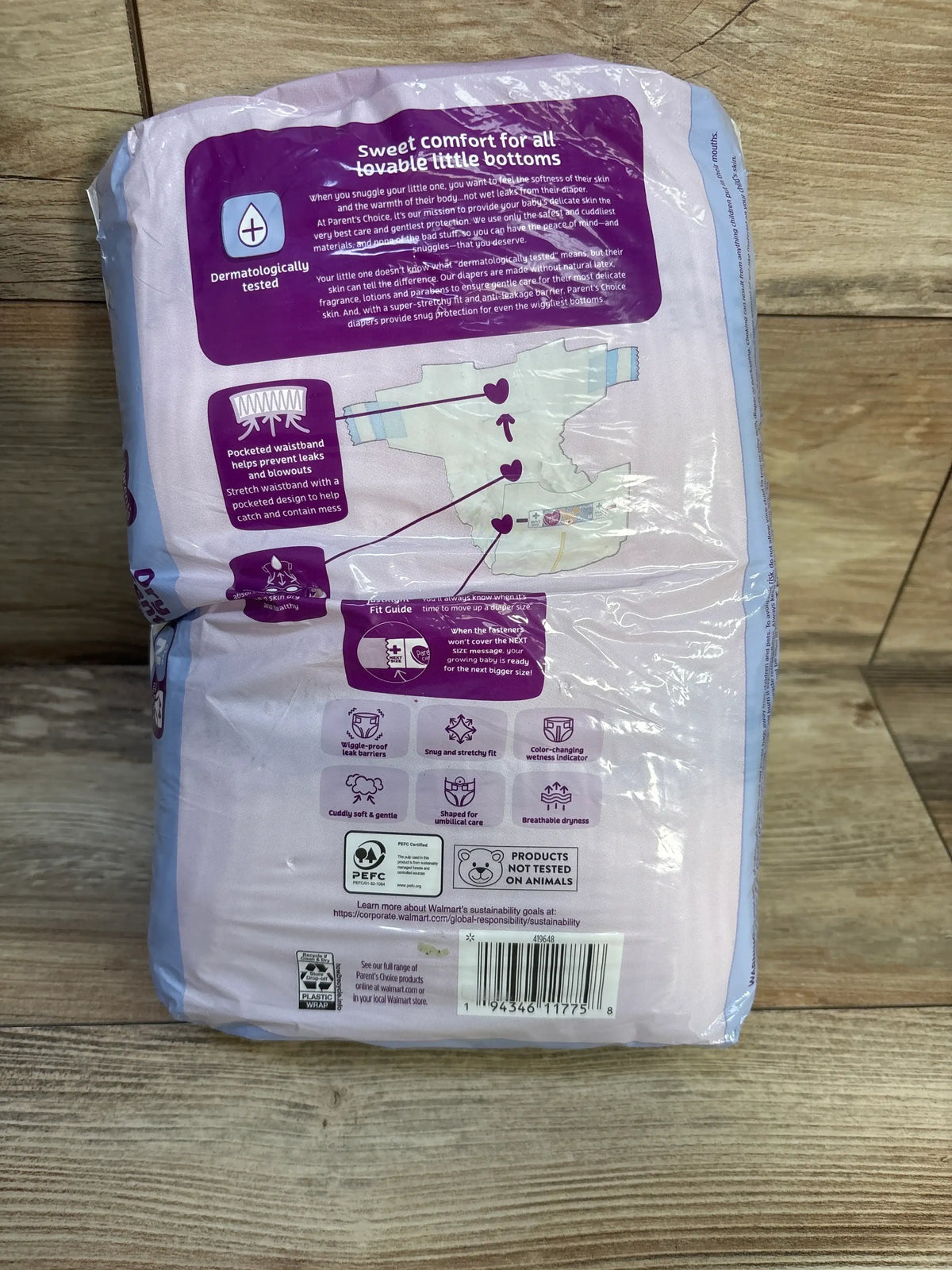 Back of Parent’s Choice Dry and Gentle Newborn diapers showing wetness indicator and leak protection on wood floor