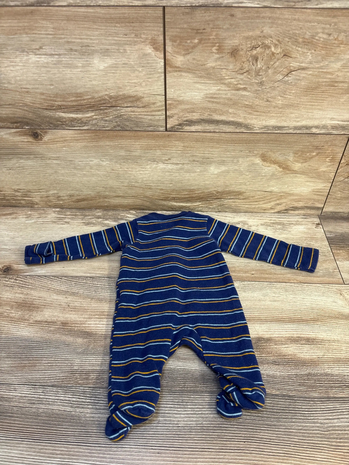 Navy blue striped baby footed sleeper on wood floor, gently used kids clothing