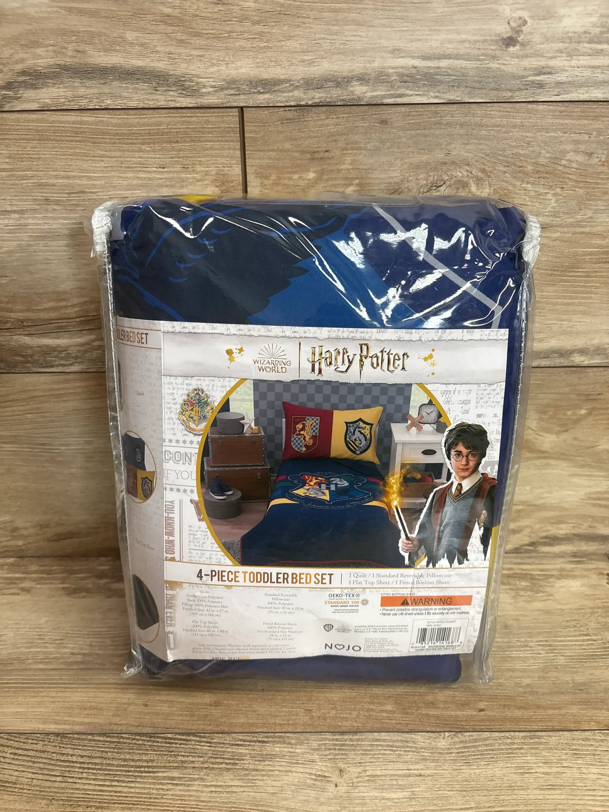 Front view of packaged Harry Potter 4-piece toddler bed set with navy comforter and Hogwarts crests