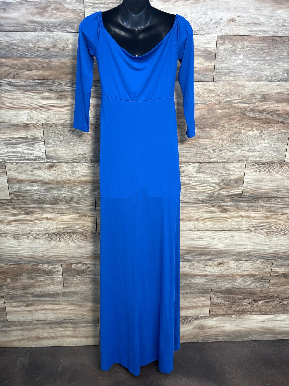 Long royal blue dress with three-quarter sleeves on black mannequin against wood panel background