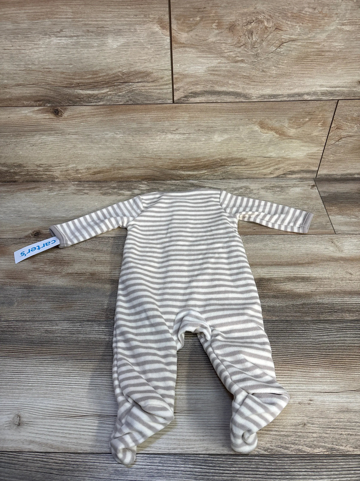 Front view of Carters beige striped blanket sleeper with footed legs and long sleeves on wood look background