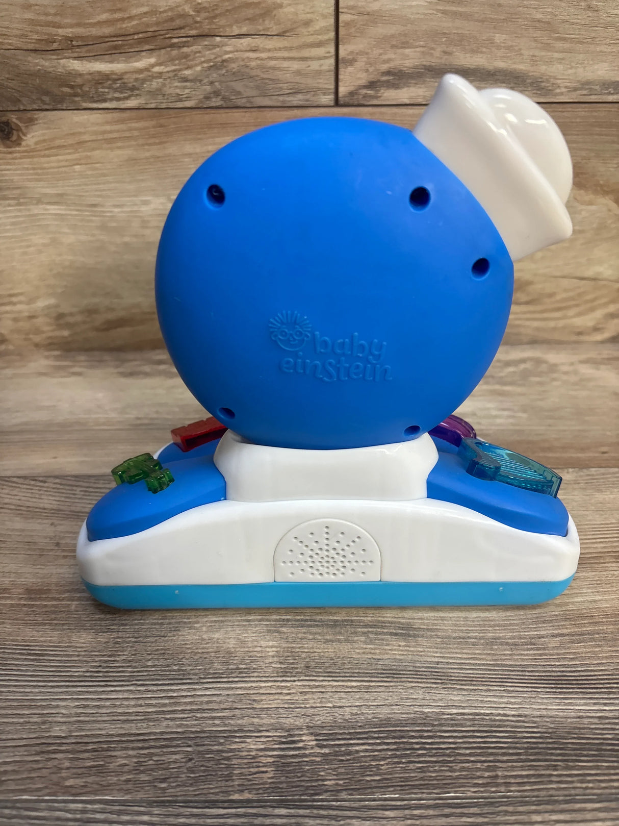 Blue and white Baby Einstein musical toy for toddlers on wood background