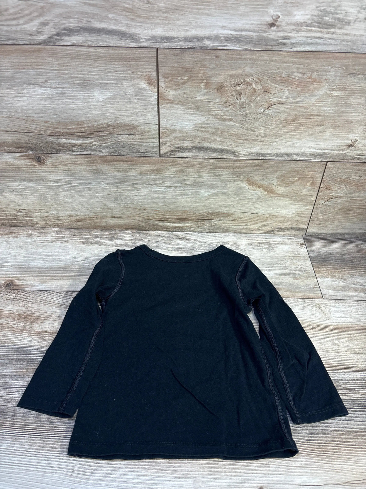 Back view of Cat and Jack black long-sleeve toddler shirt 4T with crew neckline and side seam detail on wood floor